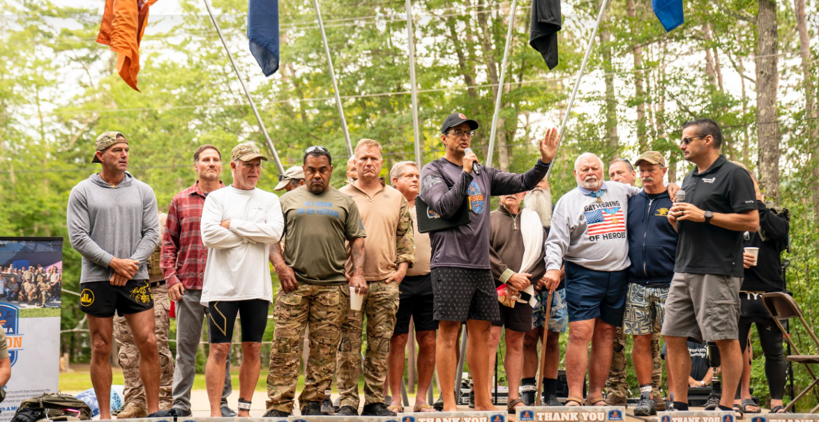 Group of veterans standing together on a stage at an outdoor community event